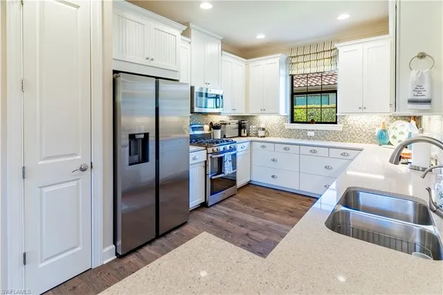 a large white kitchen with a sink and dishwasher stove
