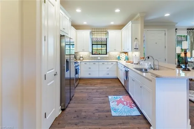 a large white kitchen with a sink and cabinets