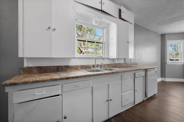 a bathroom with a granite countertop sink mirror and cabinets