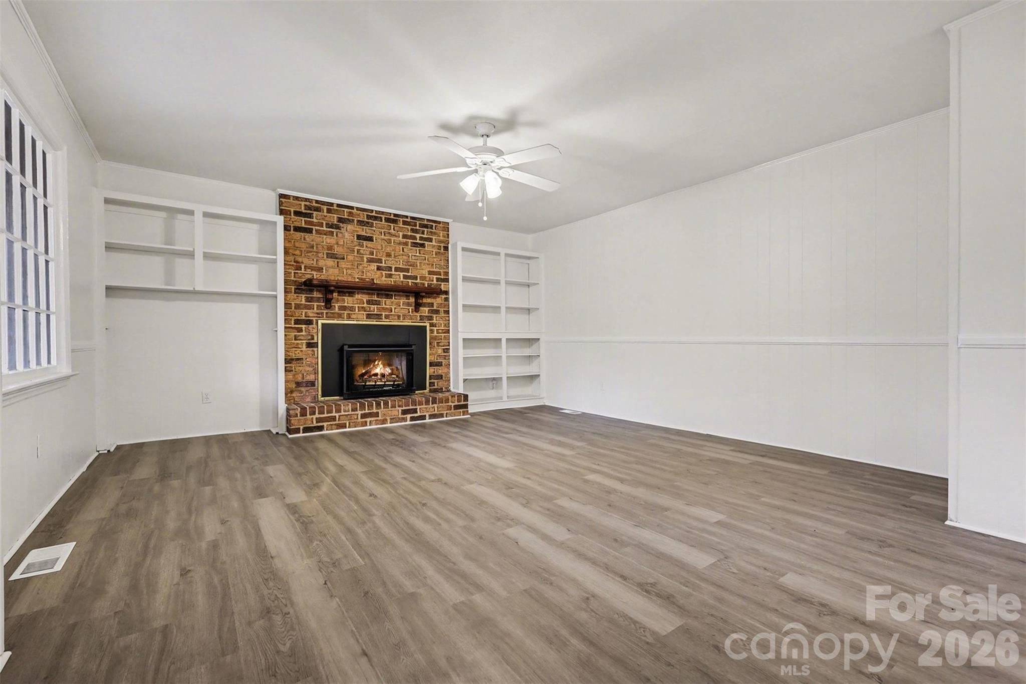1343 Cedar Pines Lake Road Lancaster, SC 29720 - Photo 4 of 25 a view of empty room with wooden floor and fireplace