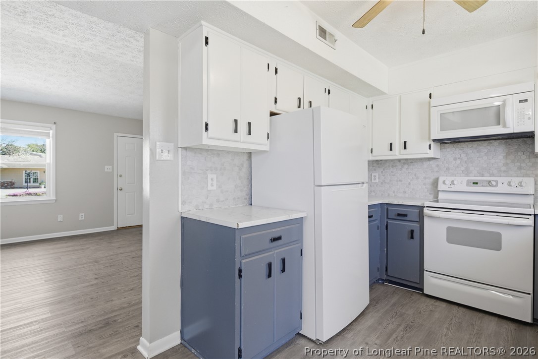 6319 Rustic Ridge Hope Mills, NC 28348 - Photo 14 of 39 a kitchen with white cabinets and white appliances