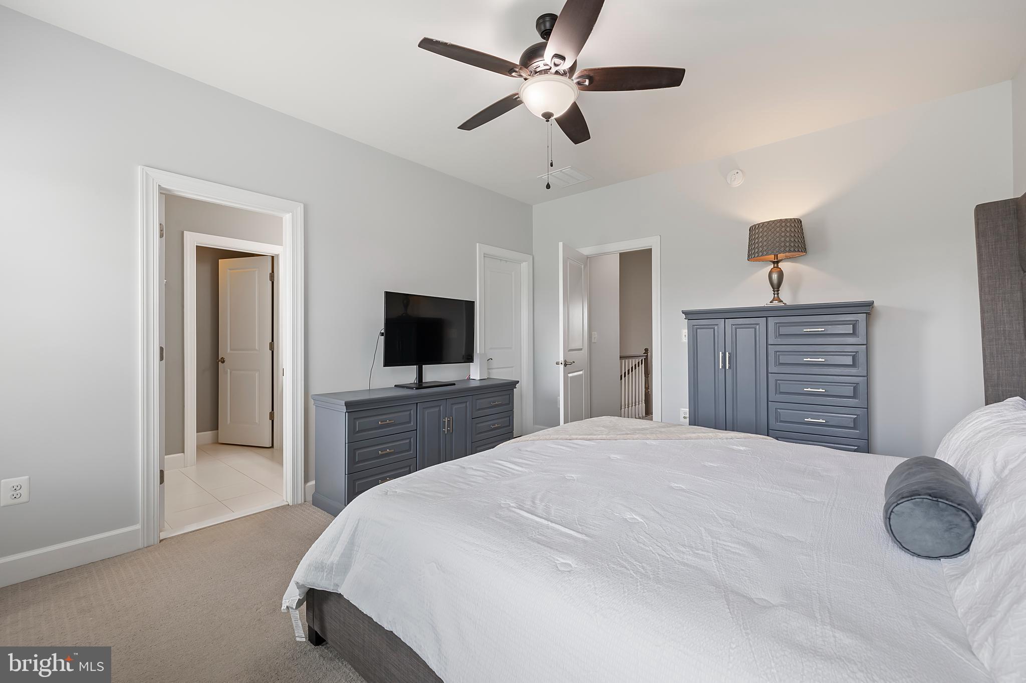 7071 Mongoose Trail Gainesville, VA 20155 - Photo 32 of 51 a bedroom with a bed a mirror and a flat tv screen on dresser