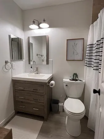 a bathroom with a toilet sink and mirror