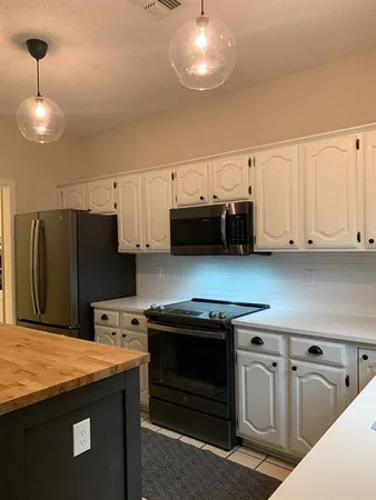 a kitchen with stainless steel appliances granite countertop a stove a refrigerator and a microwave