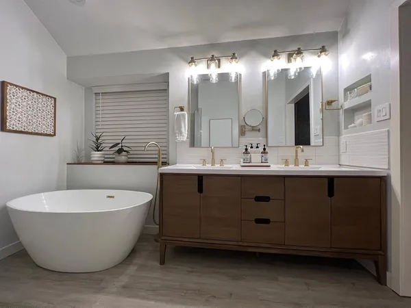 a spacious bathroom with a double vanity sink mirror and bathtub