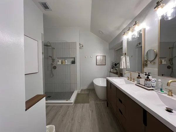 a bathroom with a double vanity sink toilet and shower