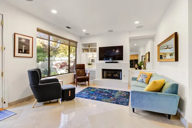 a living room with furniture a flat screen tv and a fireplace