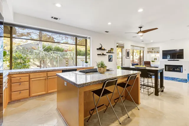 a kitchen with stainless steel appliances granite countertop table chairs sink and cabinets