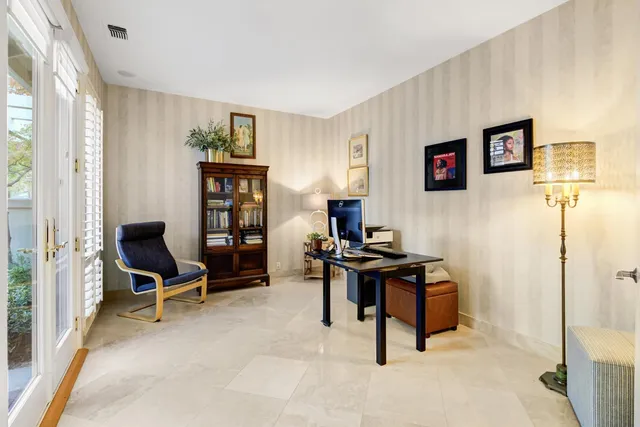 a view of a workspace with furniture and a window