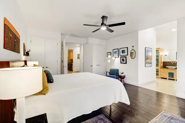 a bedroom with a bed and dresser with mirror