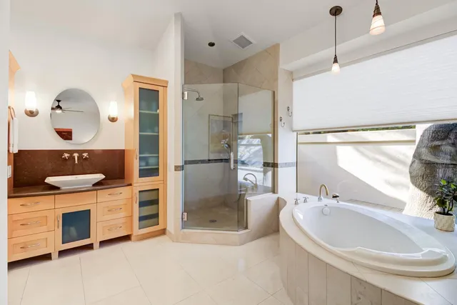 a bathroom with a sink a granite counter and a glass door shower