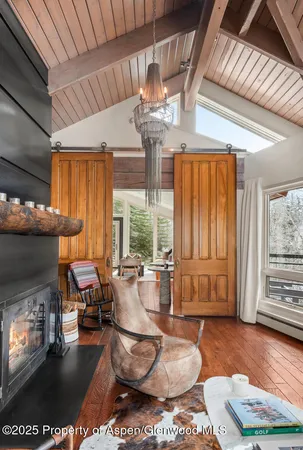 a living room with fireplace furniture and a large window