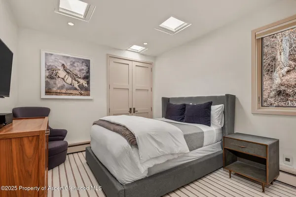 a bedroom with a bed and a lamp on dresser
