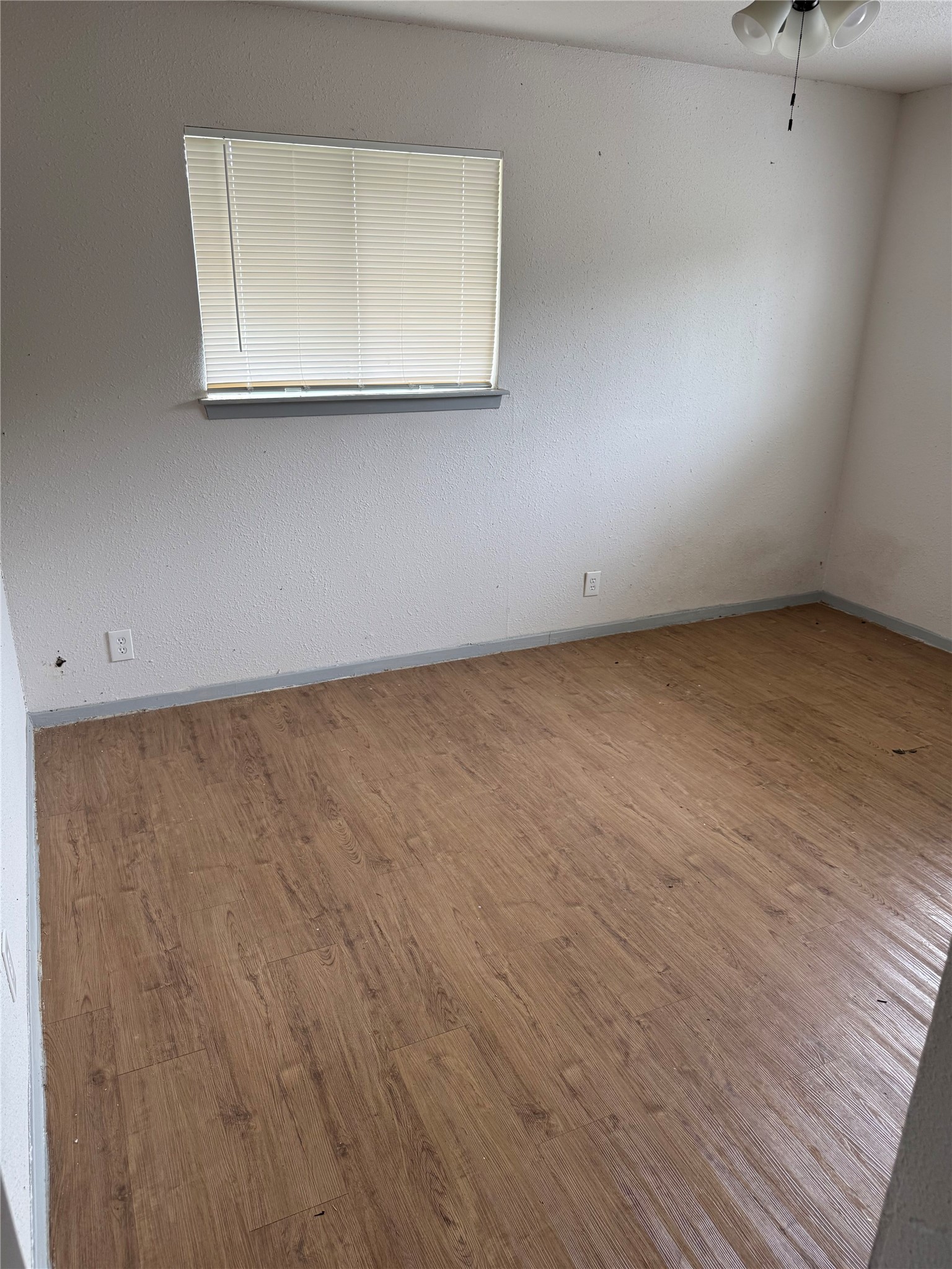 1303 Falcon Cove Austin, TX 78745 - Photo 8 of 16 an empty room with a wooden floor and a window