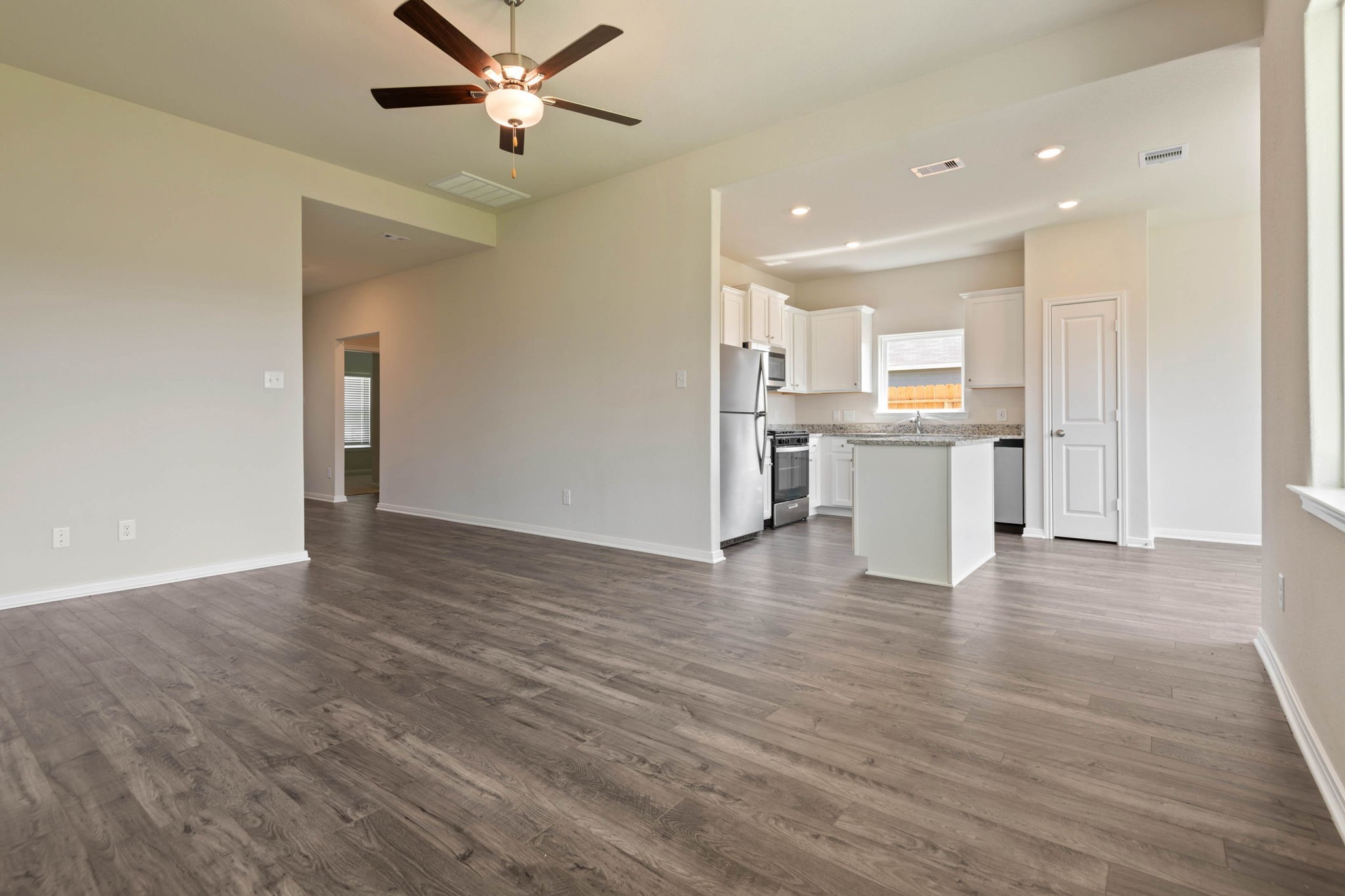 10351 Red Cardinal Drive Cleveland, TX 77328 - Photo 6 of 25 a view of kitchen with stainless steel appliances wooden floor dining table and chairs