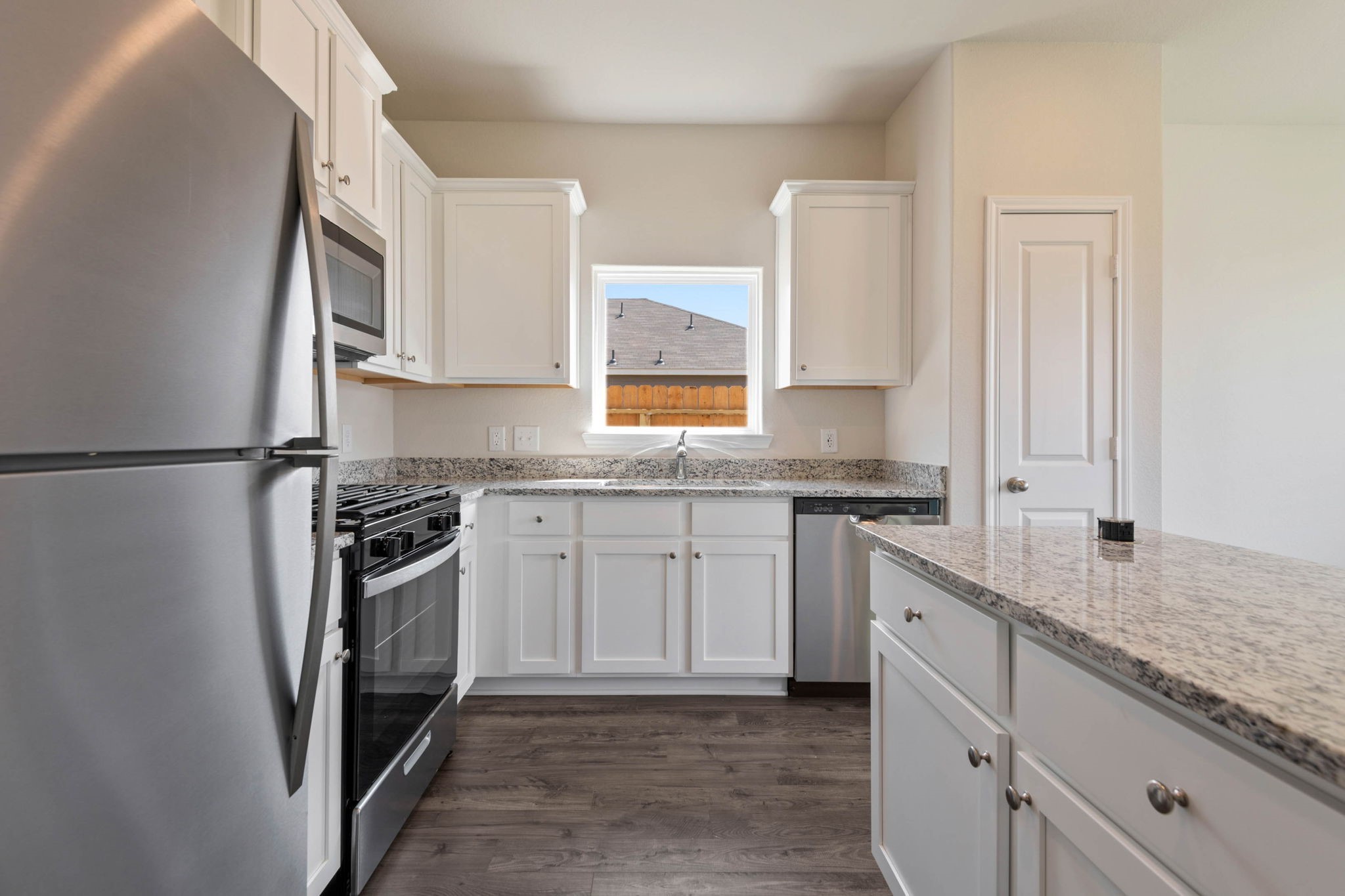 10351 Red Cardinal Drive Cleveland, TX 77328 - Photo 8 of 25 a kitchen with stainless steel appliances granite countertop a sink stove and refrigerator