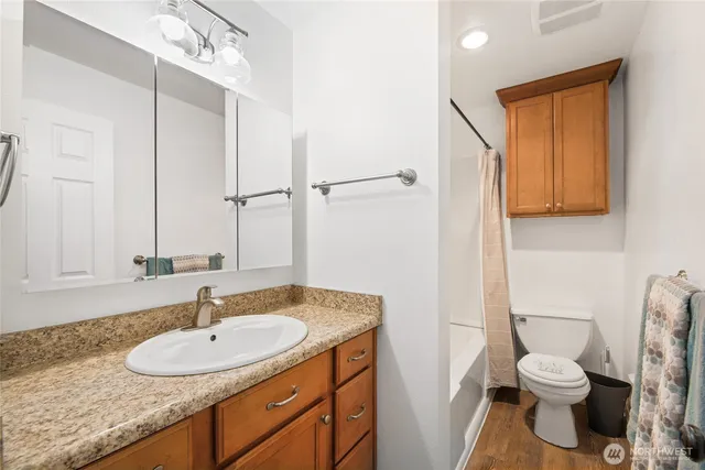 a bathroom with a granite countertop sink toilet and shower