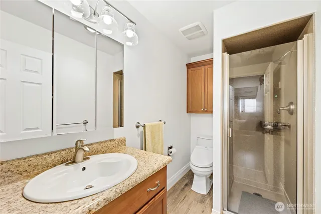 a bathroom with a sink a toilet and shower