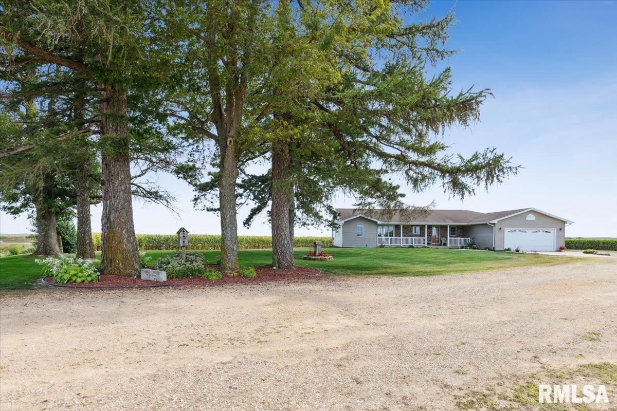 3983 120th Street Bryant, IA 52727 - Photo 11 of 62 a front view of a house with a yard and trees