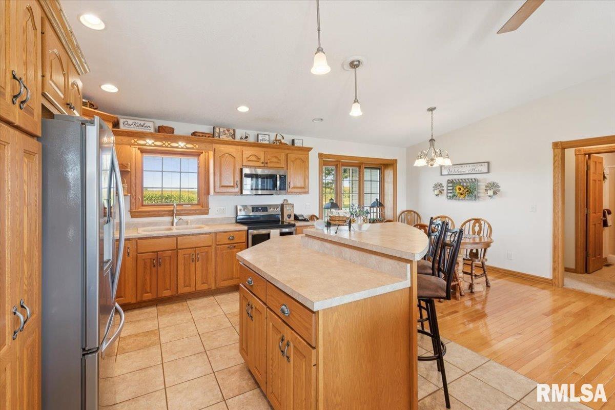3983 120th Street Bryant, IA 52727 - Photo 23 of 62 a kitchen with kitchen island a stove a table and chairs in it
