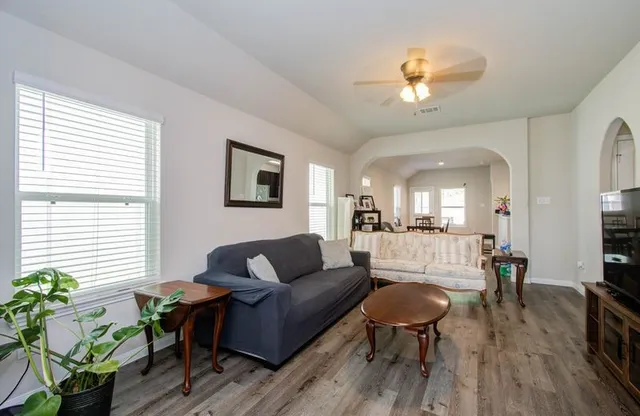 a living room with furniture and a wooden floor