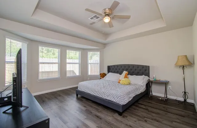 a bedroom with a bed window and a flat screen tv