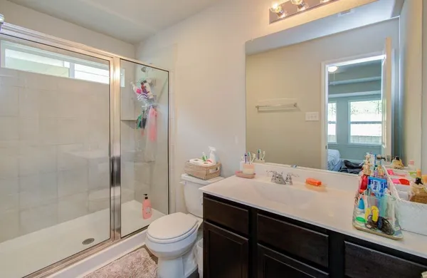 a bathroom with a sink a toilet and shower