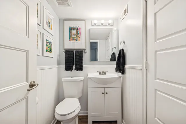 a bathroom with a toilet sink and mirror