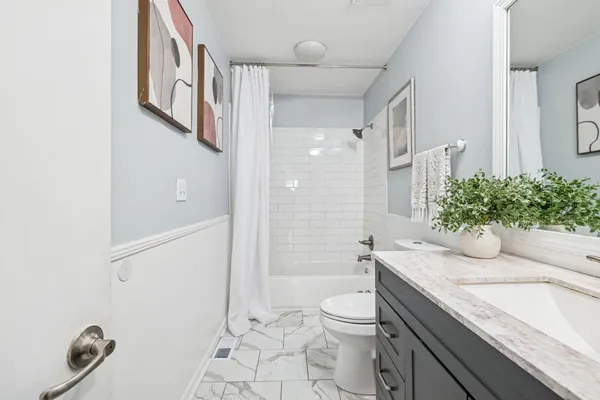 a bathroom with a granite countertop sink a toilet and shower