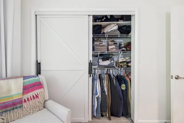 a view of walk in closet with clothes and shoes