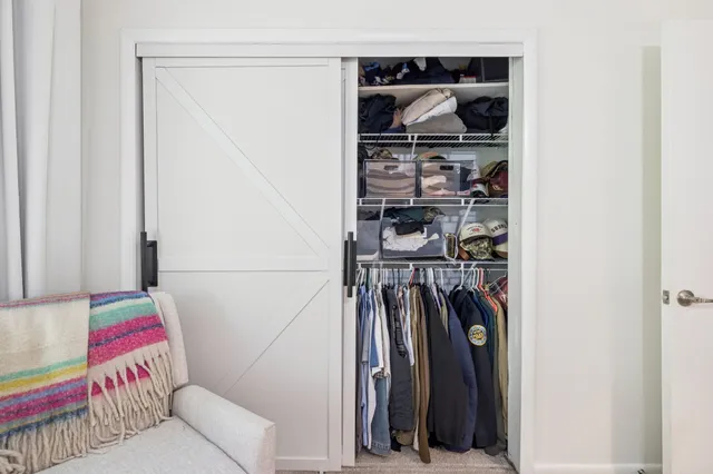 a view of walk in closet with clothes and shoes