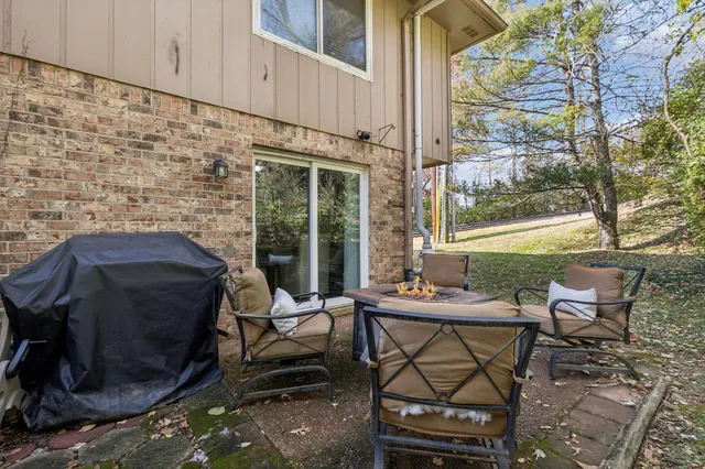 a patio with table and chairs and potted plants