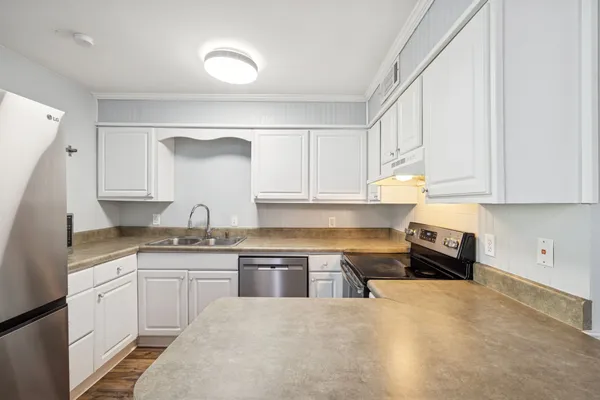 a kitchen with granite countertop a sink and cabinets