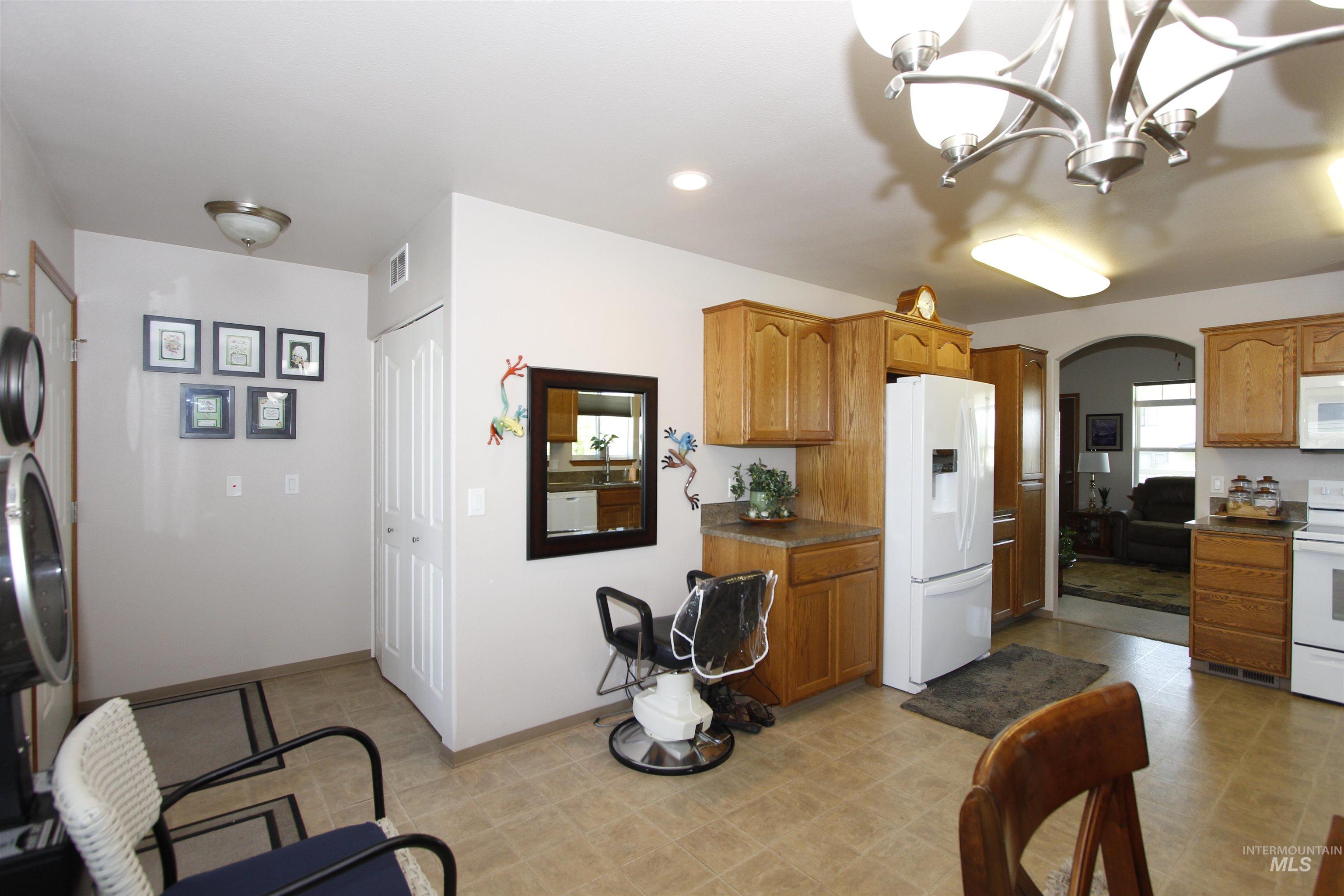 1803 16th Street Lewiston, ID 83501 - Photo 11 of 22 Kitchen featuring wood-finish cabinetry, white appliances, and a tiled floor