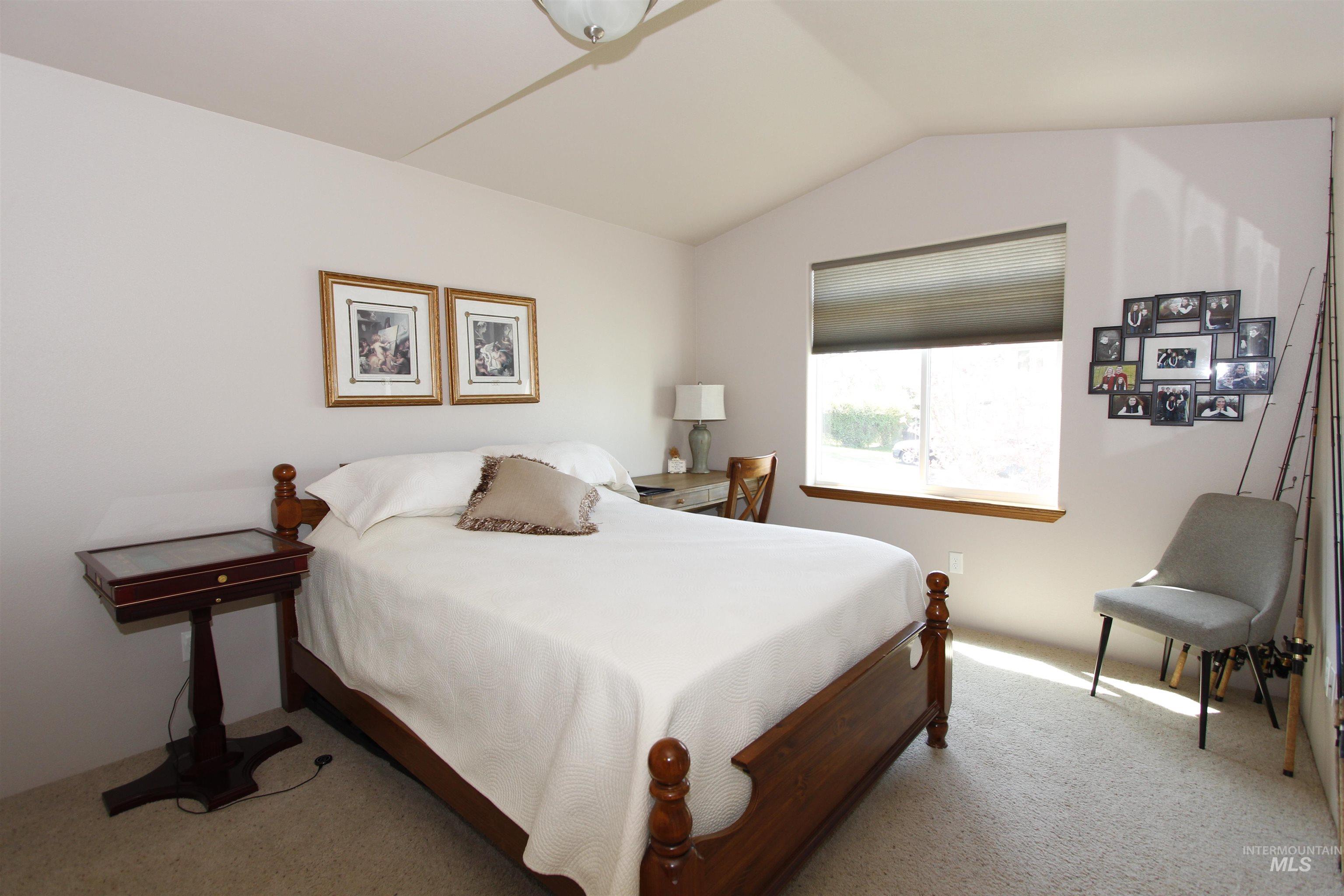 1803 16th Street Lewiston, ID 83501 - Photo 16 of 22 Vaulted ceiling bedroom featuring a large window, neutral wall tones, and carpet flooring