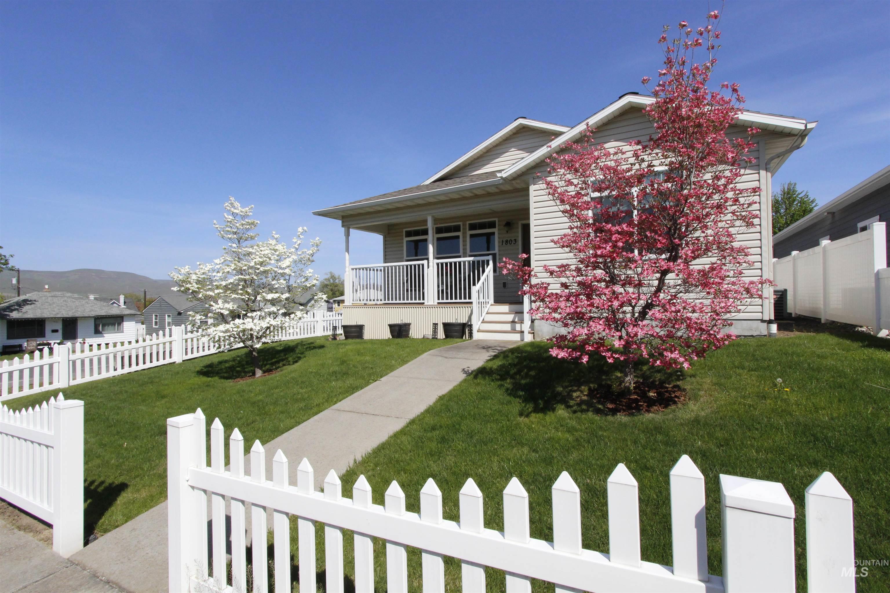 1803 16th Street Lewiston, ID 83501 - Photo 2 of 22 Front exterior featuring a covered porch, durable siding, a concrete pathway, a picket fence, and mature trees