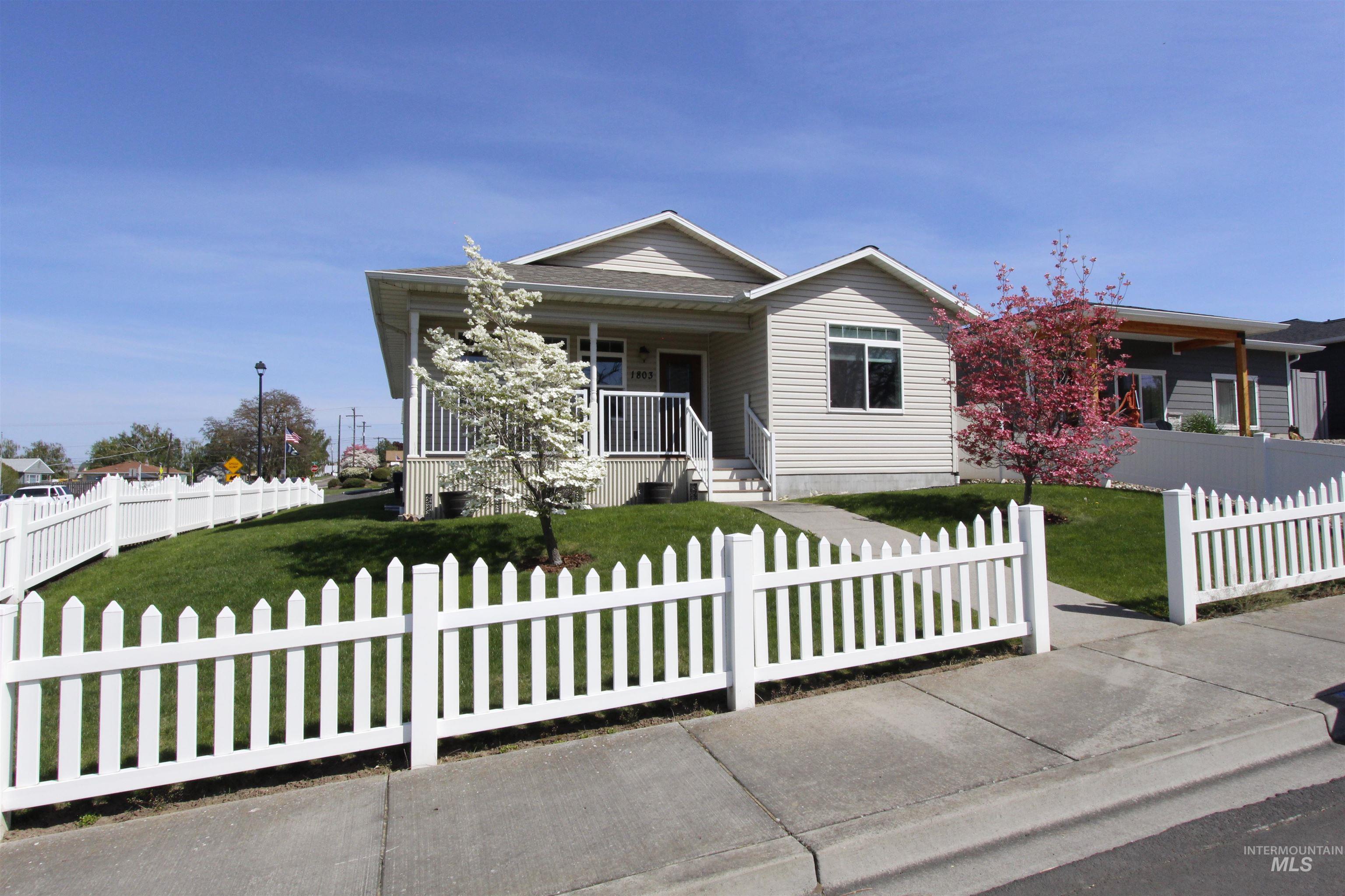 1803 16th Street Lewiston, ID 83501 - Photo 3 of 22 Siding exterior with a white picket fence enclosing a manicured lawn