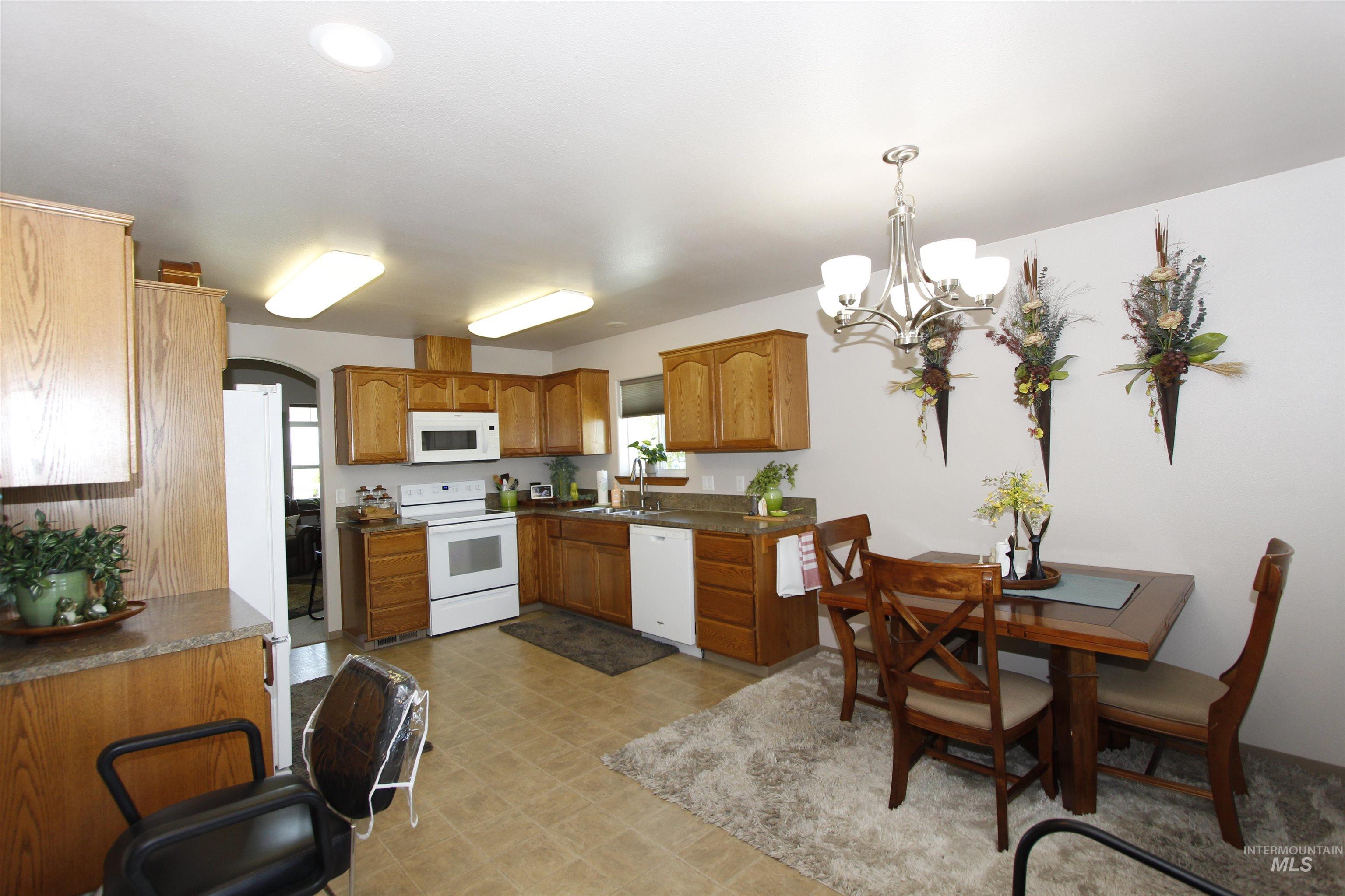 1803 16th Street Lewiston, ID 83501 - Photo 10 of 22 Spacious kitchen featuring wood-finish cabinetry, white appliances, and laminate countertops