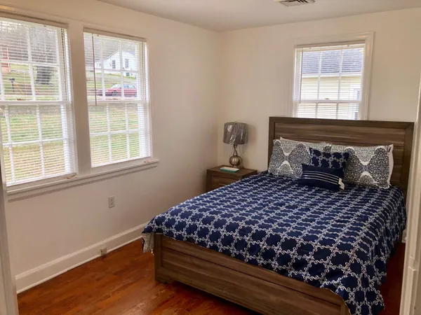 a bedroom with a bed and wooden floor
