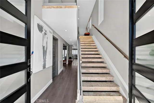 a view of staircase with wooden floor and white walls