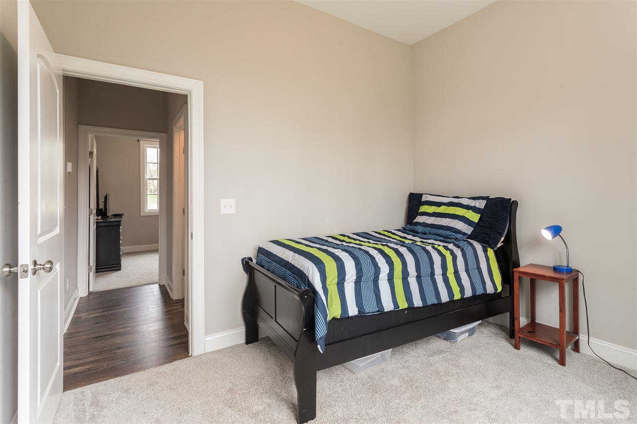 3318 High Gate Road Raleigh, NC 27603 - Photo 13 of 16 a bedroom with a bed and wooden floor