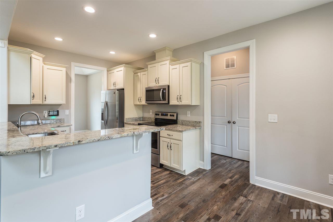 3318 High Gate Road Raleigh, NC 27603 - Photo 3 of 16 a kitchen with a sink a microwave a refrigerator and cabinets