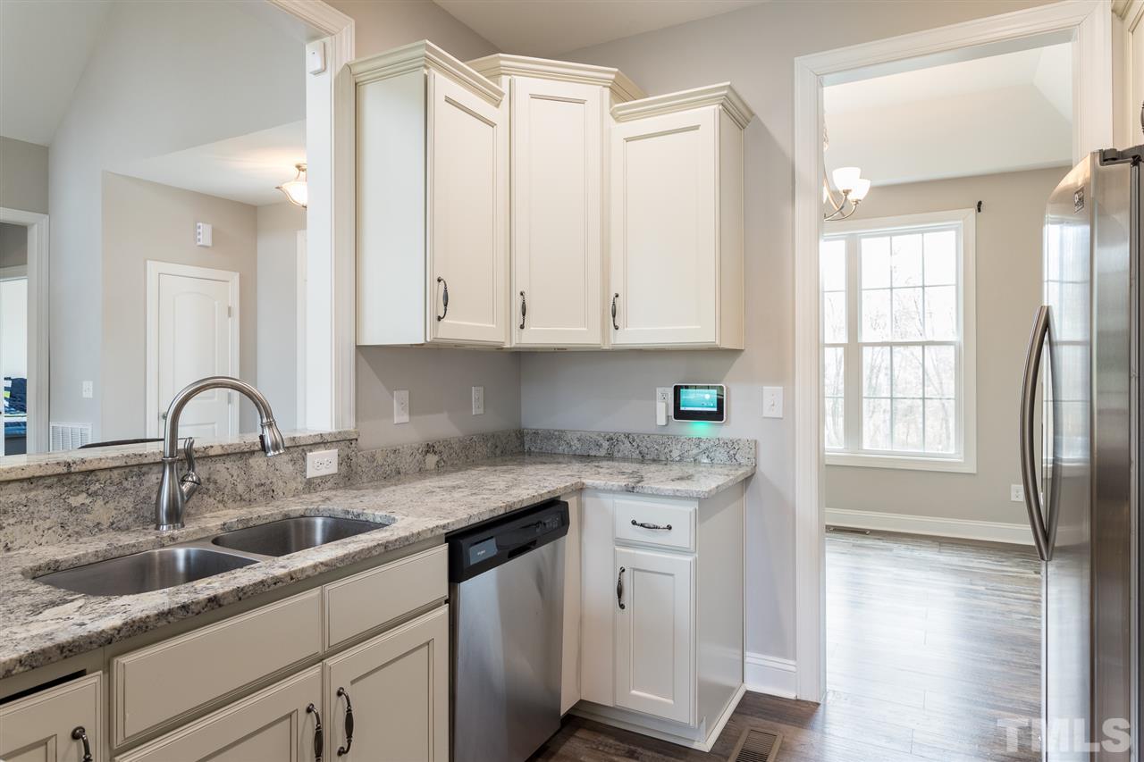 3318 High Gate Road Raleigh, NC 27603 - Photo 4 of 16 a kitchen with stainless steel appliances granite countertop a sink a stove and cabinets