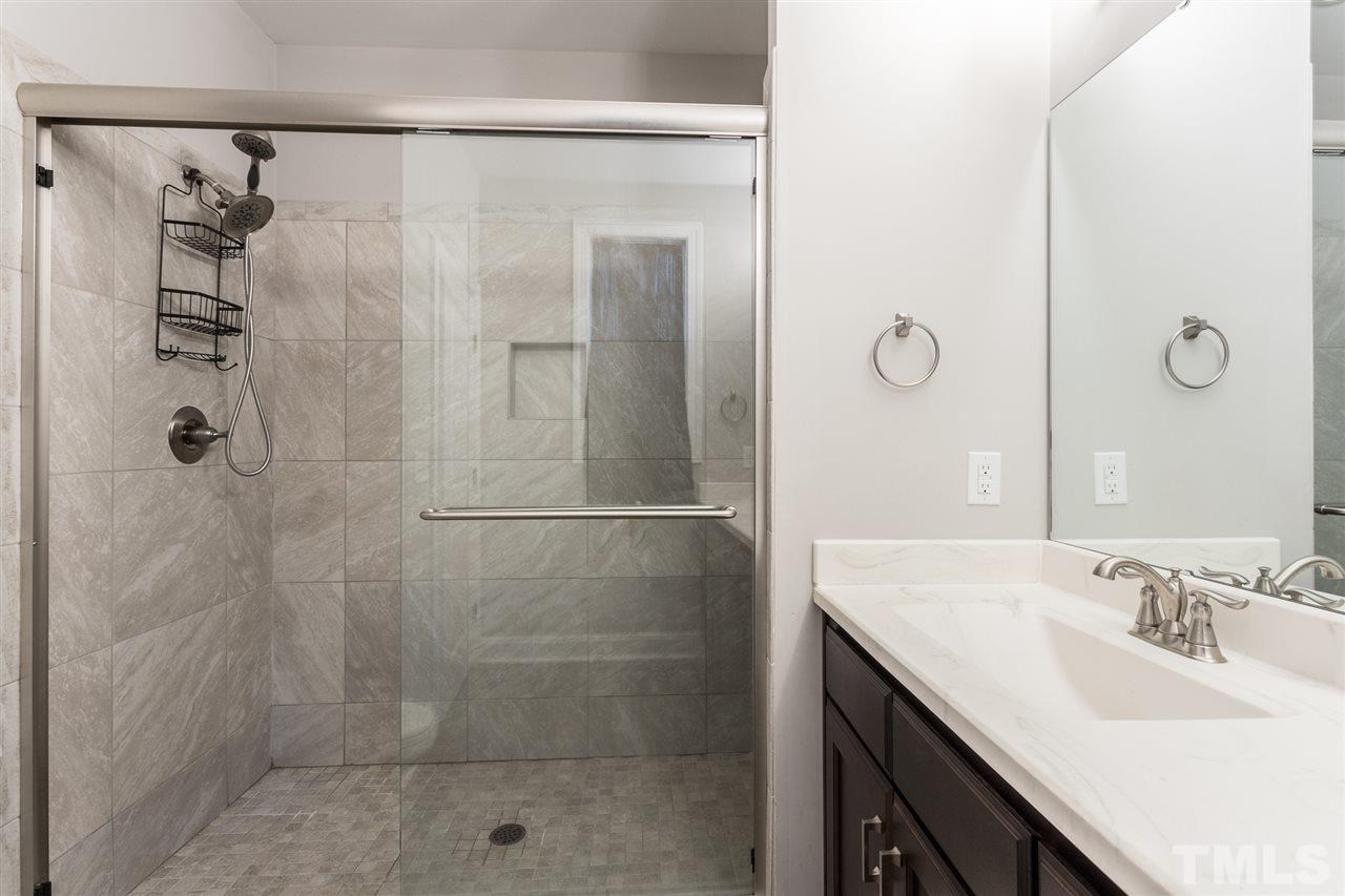 3318 High Gate Road Raleigh, NC 27603 - Photo 8 of 16 a bathroom with a granite countertop shower a sink and mirror