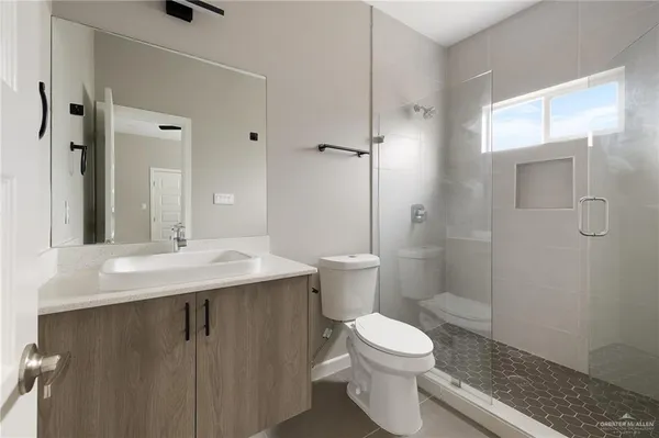 a bathroom with a sink a toilet and shower