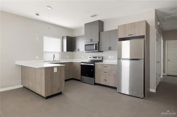 a kitchen with cabinets stainless steel appliances and a window