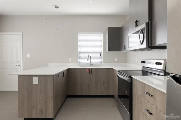 a kitchen with granite countertop a sink dishwasher stove and cabinets