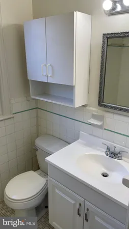 a bathroom with a toilet sink and mirror