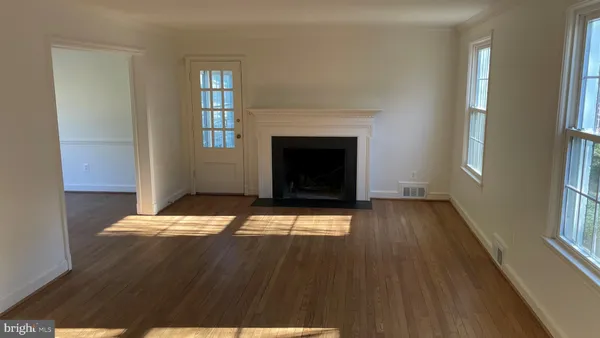 a view of a livingroom with wooden floor and a fireplace