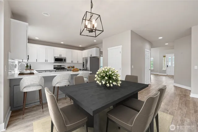 a kitchen with refrigerator a microwave a stove and white cabinets